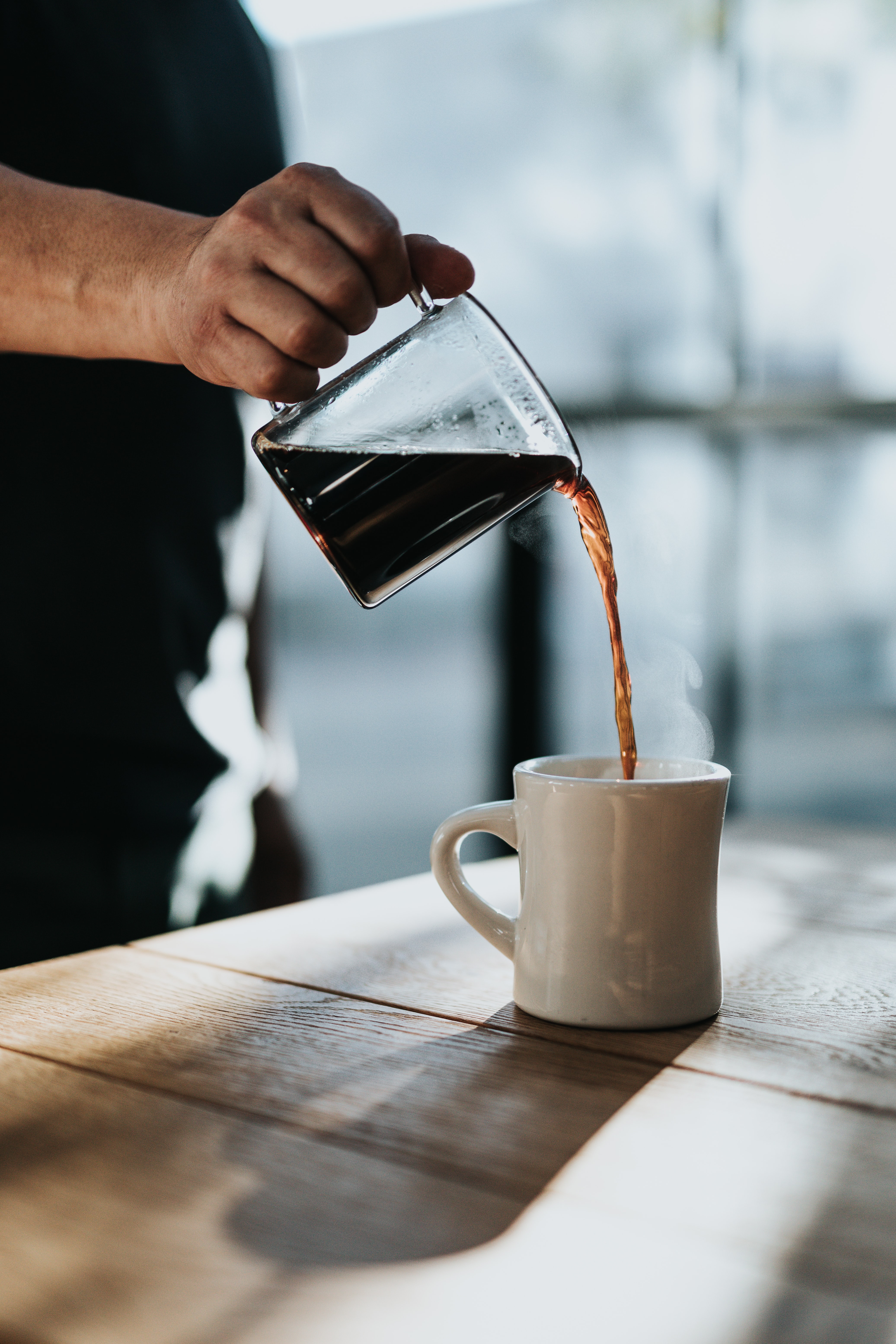 Man pouring coffee into mug