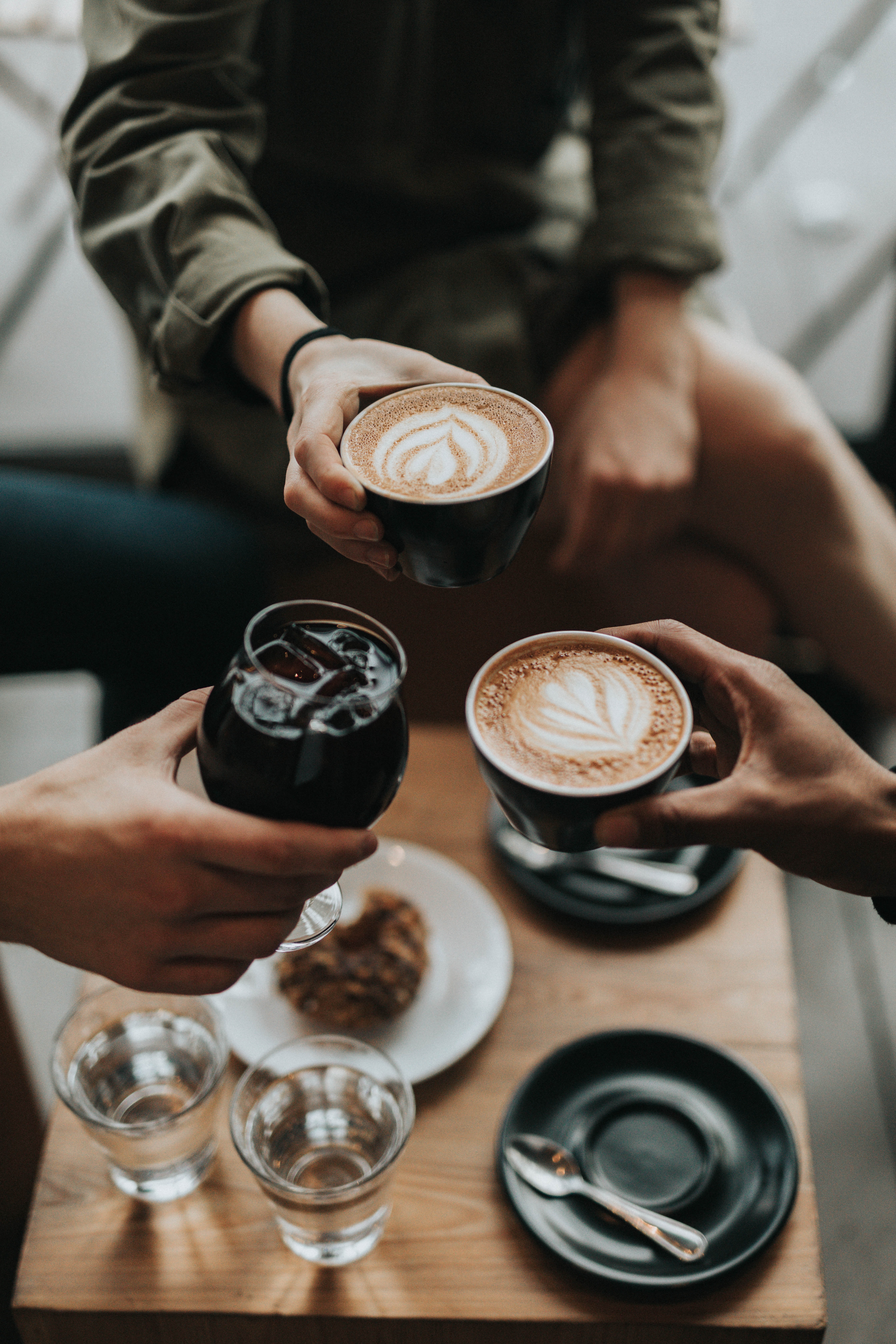 Three people cheerings cups with coffee